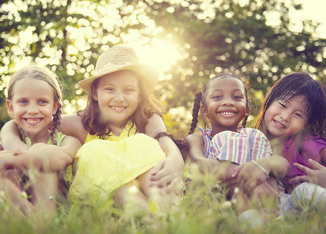 Quatre enfants en train de sourire dans le gazon