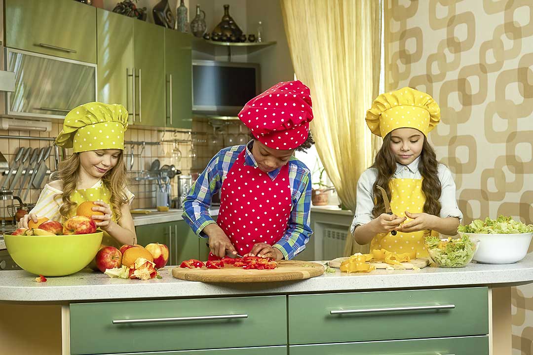 Three children learning to cook