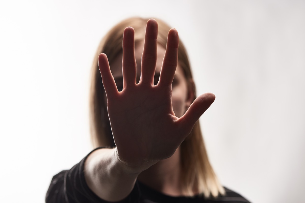 Selective focus of the victim showing a stop sign isolated on a white background