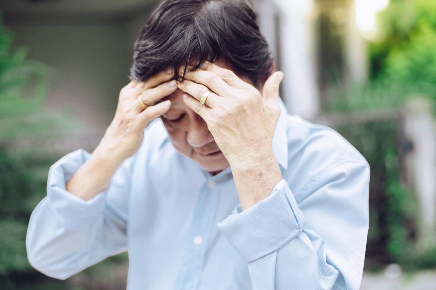 Homme âgé couvrant son visage avec ses mains souffrant de problèmes