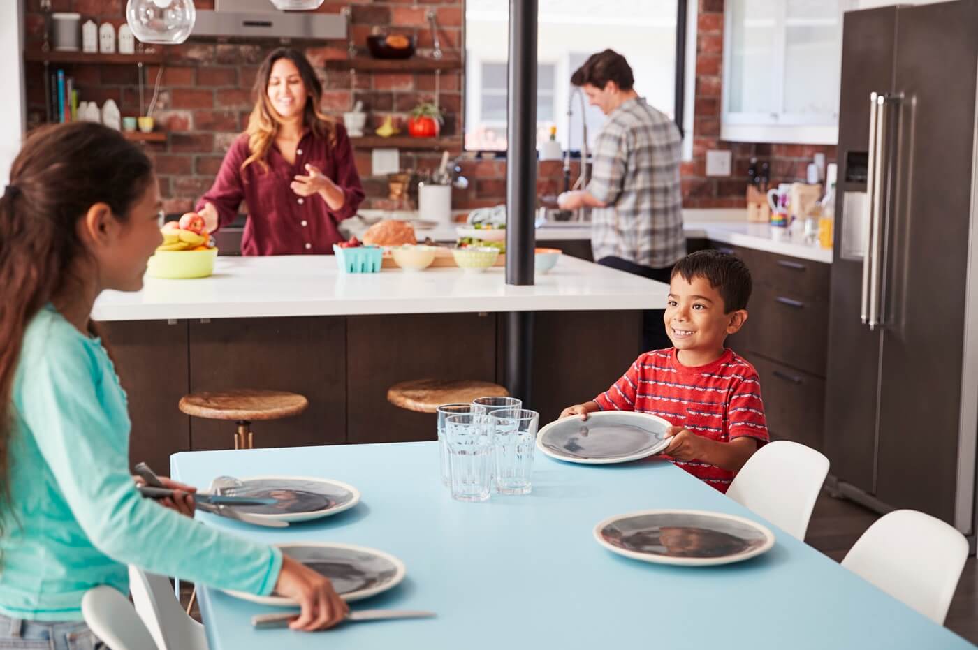 Des enfants aident à poser une table prête pour le repas de famille