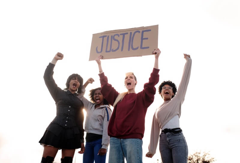 A group of women at a protest shouting and demanding justice on women's rights