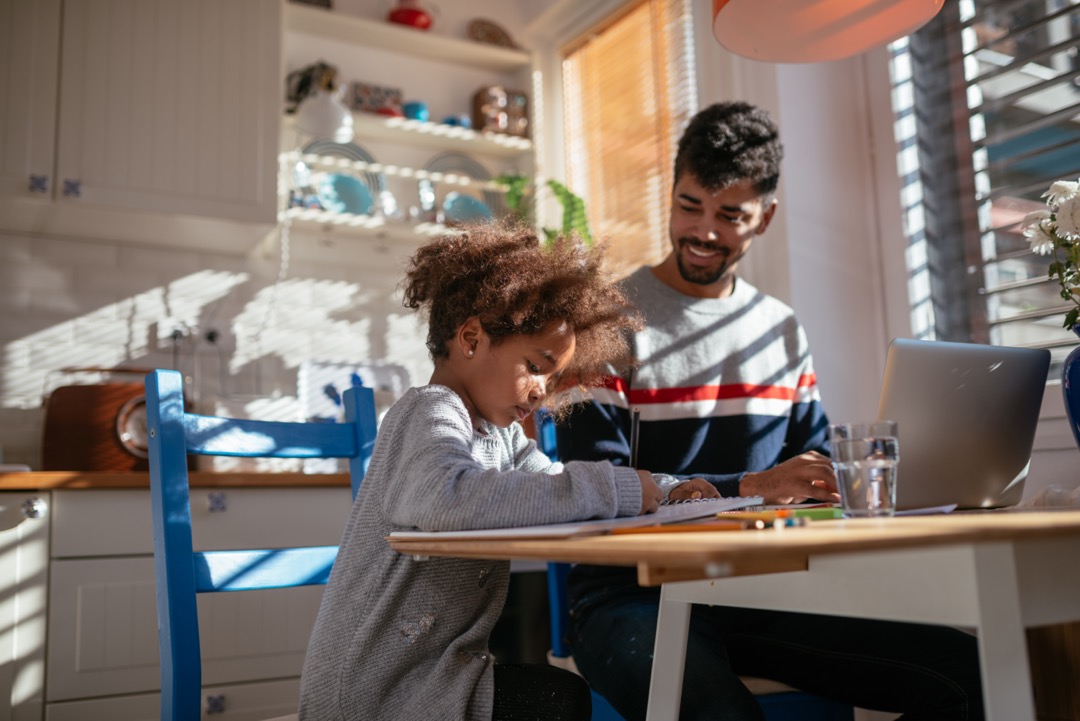 Plan d'un jeune père et de sa fille s'entraidant dans la cuisine.