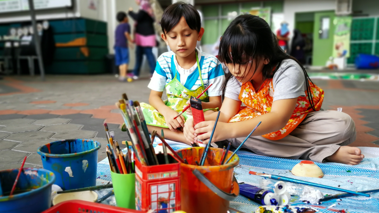 deux enfants en train de faire de la peinture