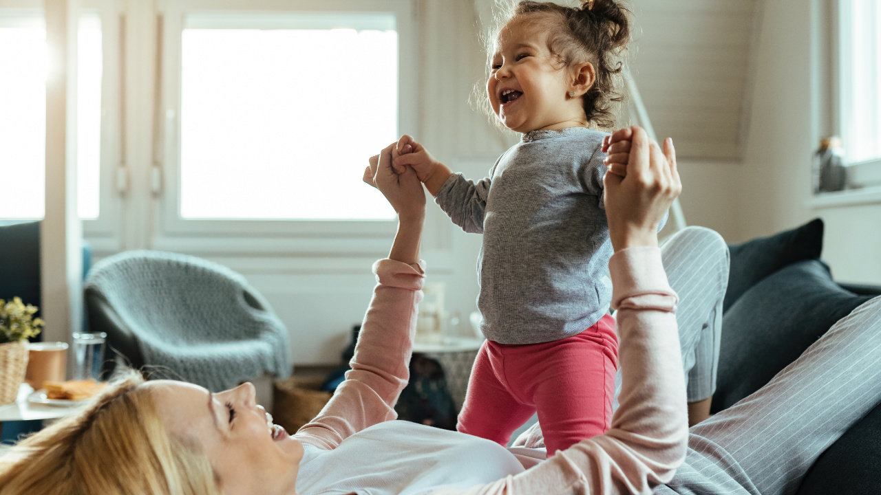mother playing with her little girl in a living room